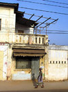 Lomé, Togo: woman walks in front of an old colonial building - photo by G.Frysinger